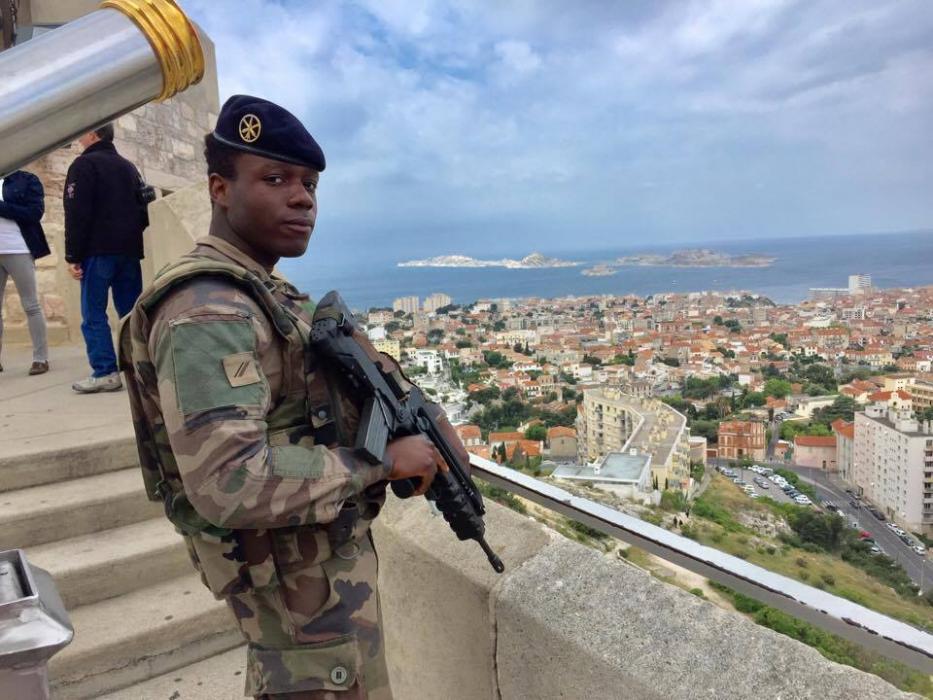Un soldato a Notre Dame de la Gard di fronte al panorama, con le isole