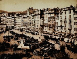 1. Alfred Noack, Genova. Piazza Caricamento (fotografia tra 1886 e 1895). Collezione Aldoe Vittorio Laura. "Le strade di Genova... vagano a loro capriccio intorno alle basi dei cupi palazzi di pietra, e paiono avere la passione vagabonda di strisciarsene giù verso il porto e perdervisi sotto un certo porticato cavernoso che gira intorno all'acqua secondo la curva della riva, e vi fa un crepuscolo del mezzogiorno... Gli alberghi, prestando ascolto alle strade vagabonde, sorgono intorno alle arcate cavernose... e tutti i rumori dei bastimenti raggiungono i loro ospiti." (William Dean Howells, Italian Journeys, 1867)